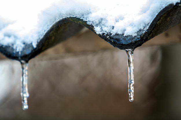 Winter ijspegels opknoping van het dak