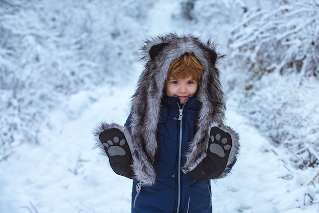 Зимний детский отдых маленький ребенок мальчик гуляет в зимнем поле детский зимний портрет концепция победы ...