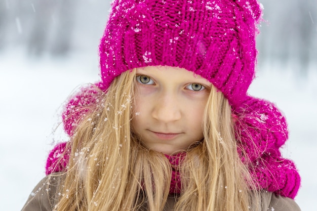 Winter - klein lachend meisje buiten tijdens de sneeuwval