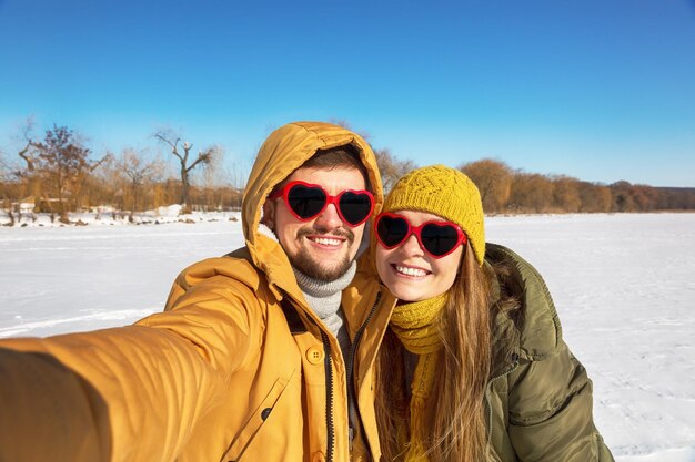 Winter kleurrijke selfie Twee verliefde mensen nemen selfie in zonnige winterdag Groothoek close-up