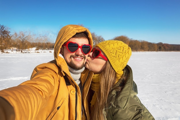 Winter kleurrijke selfie twee verliefde mensen nemen selfie in zonnige winterdag groothoek close-up