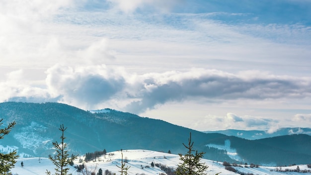 푸른 하늘이 있는 겨울에 산 위로 움직이는 겨울 풍경 안개