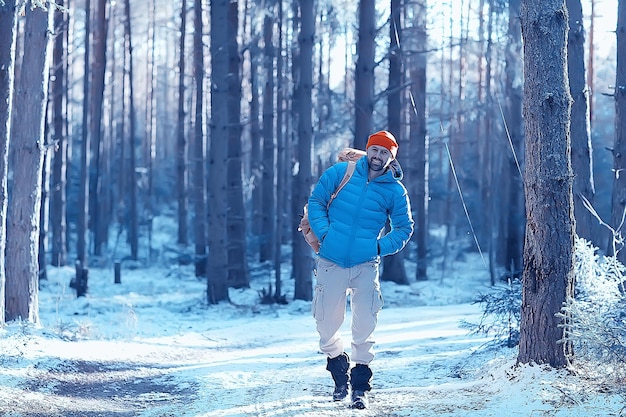 winter landscape forest backpack man / traveler in modern winter clothes in the forest, traveling in the mountains  europe, switzerland winter