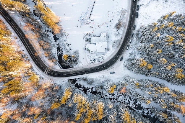 空からの冬の風景、多くの曲がりくねった山道。上からの冬の森とポーランドのカルパチ村。冬のレクリエーションセンター