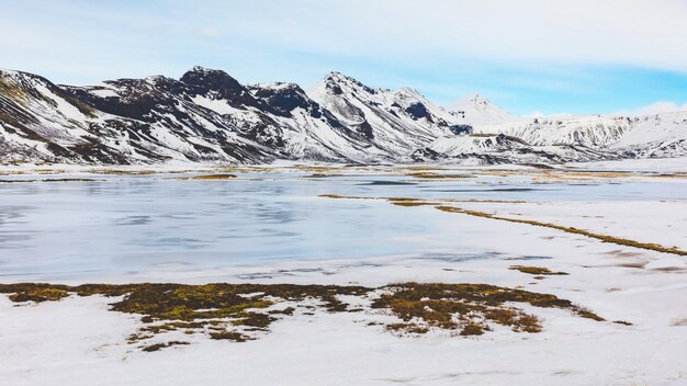 アイスランド、凍った湖と山の冬の風景