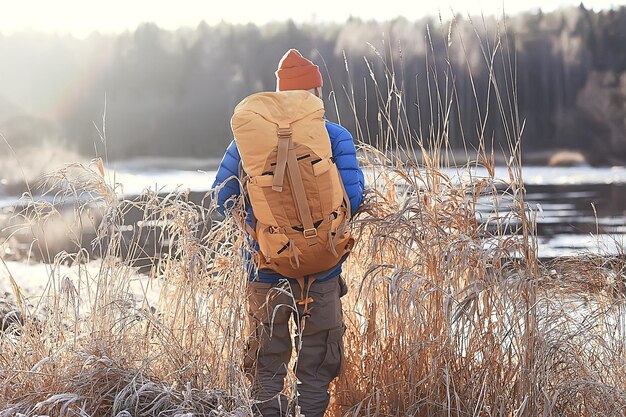 winter landscape man with a backpack / nature landscape a man on a hike with equipment in snowy weather in Canada