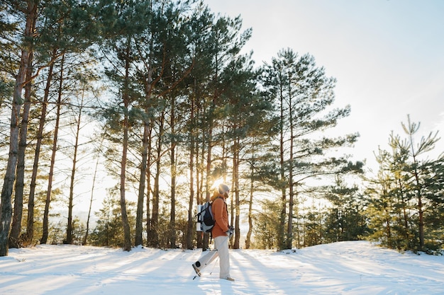 Winter landscape a man with a backpack and warm winter clothes in the forest traveling in the mountains