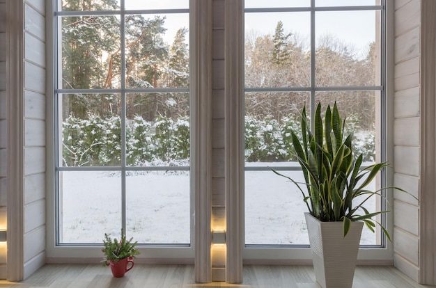 Paesaggio invernale visto attraverso la grande finestra in stile scandinavo della casa di legno
