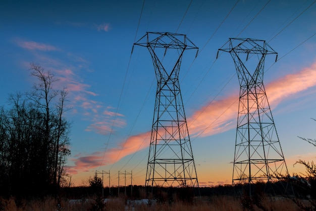 Winter landscape transmission line on a background of bright red sunset