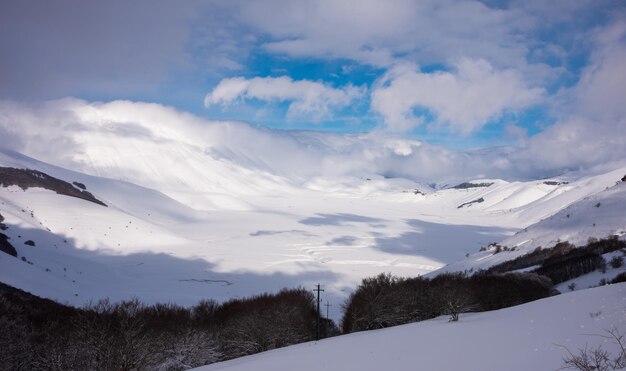 Winter landscape valley and hills covered with snow on bright sunny day