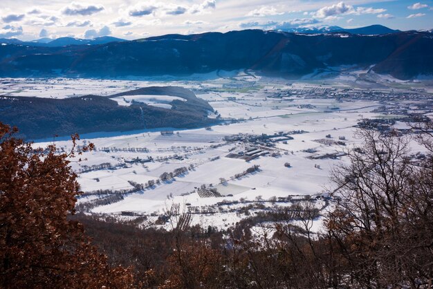 明るい晴れた日に雪で覆われた冬の風景の谷と丘