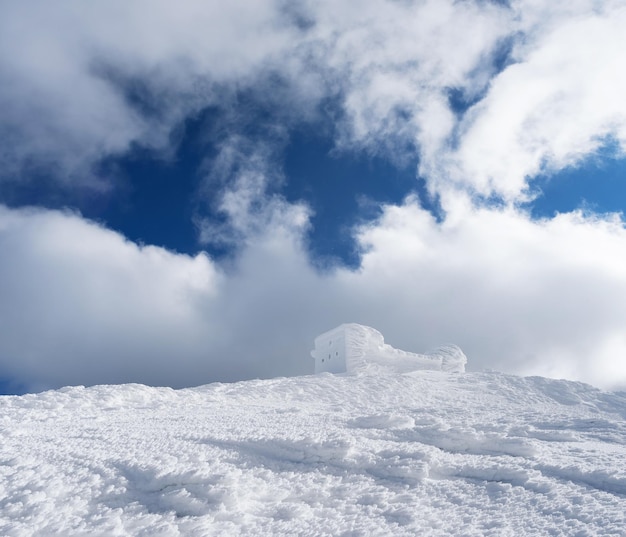 Winter landscape with a beautiful texture of the snow The old observatory on the top of the mountain Sunny day Carpathians Ukraine Europe