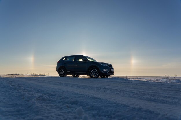 Winter landscape with car and circular halo phenomena around the sun