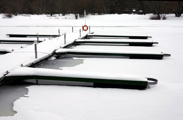 写真 季節を問わず、凍った川に雪で覆われた空のボート埠頭がある冬の風景