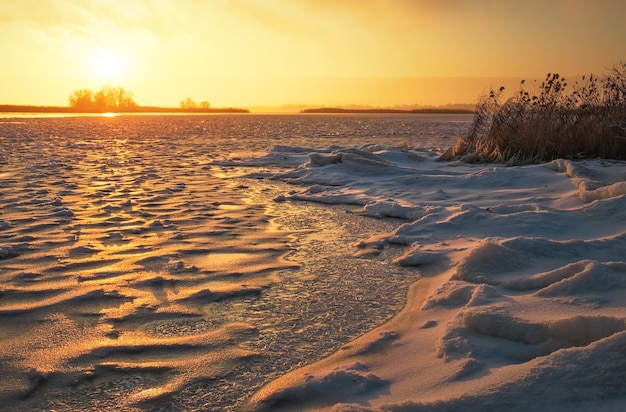Winter landscape with frozen lake and sunset fiery sky. composition of nature.