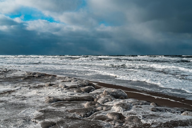 写真 凍った海と氷のビーチの劇的な海景の嵐と雪の天気と冬の風景