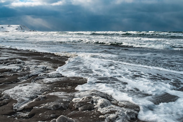 Winter landscape with frozen sea and icy beach Storm and snow weather Dramatic seascape