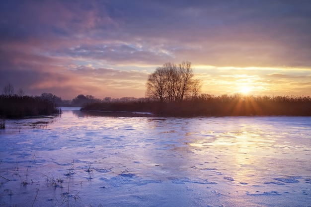 Winter landscape with sun and river. Sunrise.