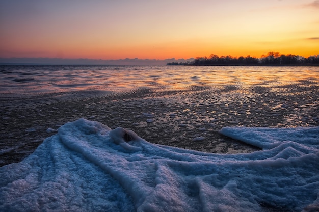 Winter landscape with sunset sky and frozen river. Daybreak

