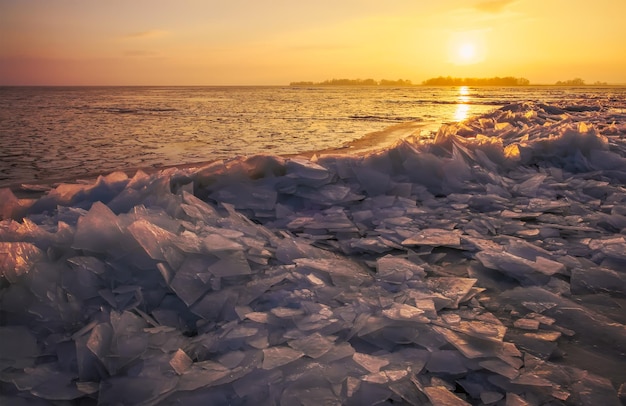 Paesaggio invernale con cielo al tramonto e costa del mare ghiacciato alba