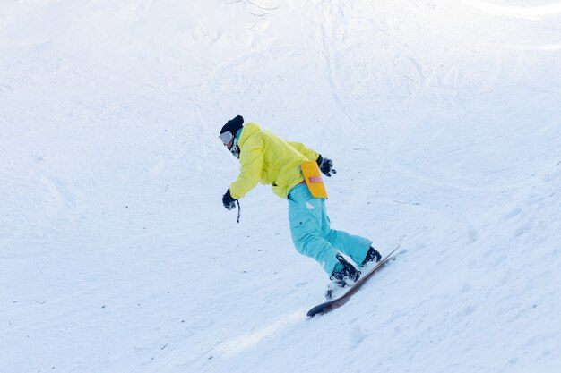 Winter, leisure, sport and people concept - active snowboarder\
jumping in mountains on a sunny day. snowboarding closeup.\
sheregesh ski resort