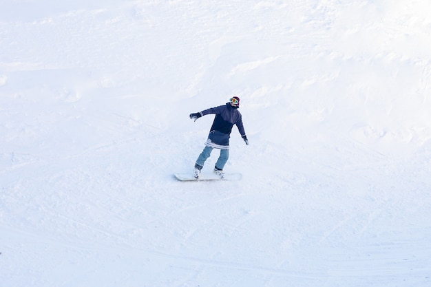 Winter, leisure, sport and people concept -active snowboarder\
jumping in mountains on a sunny day. snowboarding closeup.\
sheregesh ski resort