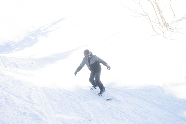 겨울, 레저, 스포츠, 사람 개념 - 화창한 날 산에서 뛰어오르는 활동적인 스노보더. 스노우 보드 근접 촬영입니다. 셰레게시 스키장