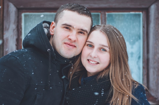 Storia d'amore invernale. marito e moglie vicino all'albero di natale coperto di neve. umore di capodanno