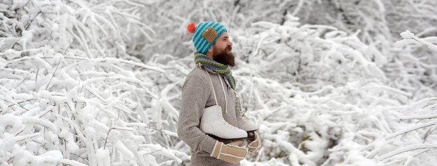 Winter man with skates in winter day winter banner attractive young man in wintertime outdoor winter