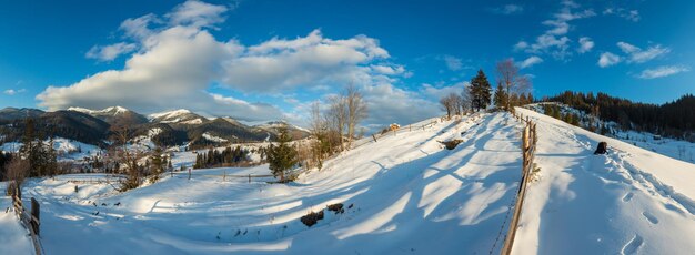 冬の朝の山の田舎の雪に覆われた小道