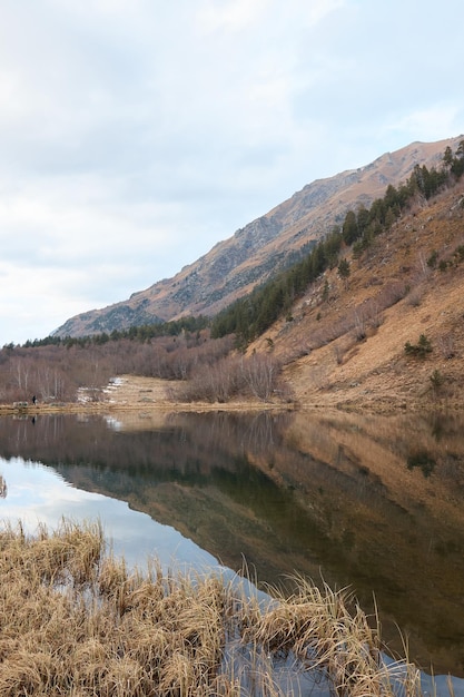 水の氷と山の風景の池の背景に雪の中で冬の山の湖