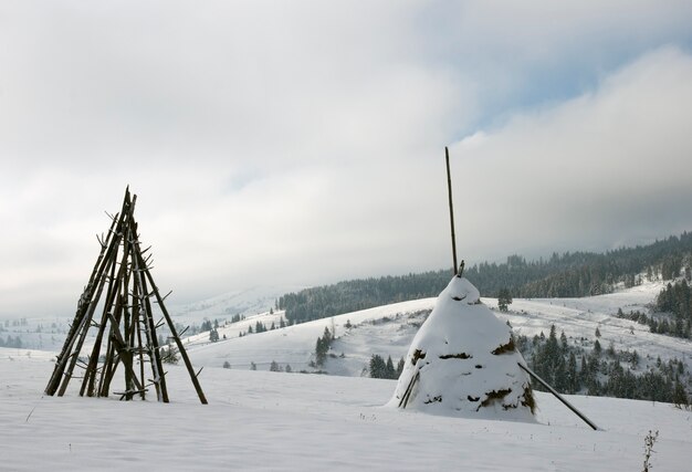 Winter mountain landscape with  haystack on a forefront