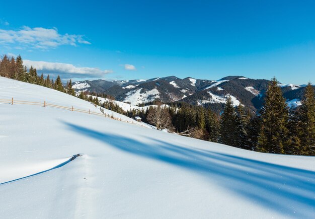 冬の山の田舎の雪が丘の斜面を覆った