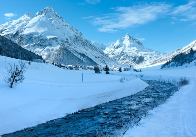 Winter mountain stream view and village in valley Austria.