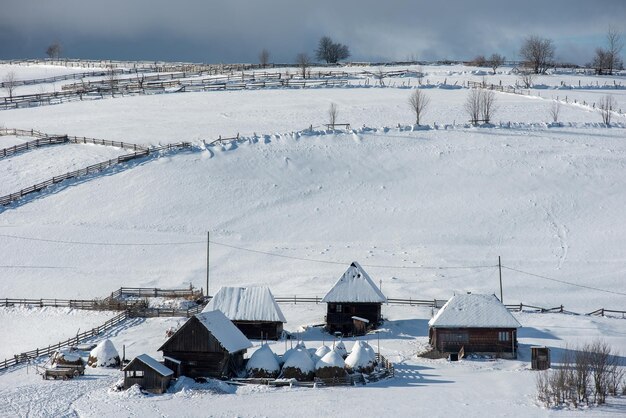 雪で覆われた家屋の冬の山の村の風景