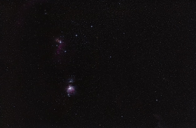 Winter night sky with purple Orion nebula many spiked stars visible