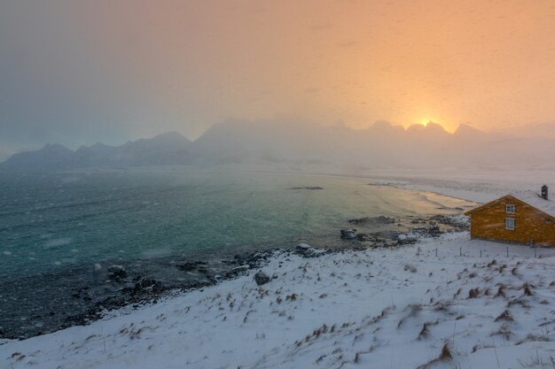 Winter Noorwegen. Lofoten. De zee baai en de dageraad over de bergen. Sneeuwval