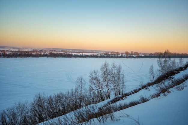 Winter oranje zonsondergang in bos over rivier tom in de buurt van kemerovo, siberië, rusland