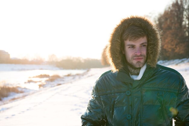 Winter outfit. Hipster fashion outfit. Guy jacket hood. Man warm jacket snowy nature background. Wind resistant clothes. Winter weather conditions. Polar explorer. Sunny winter day. Winter menswear.