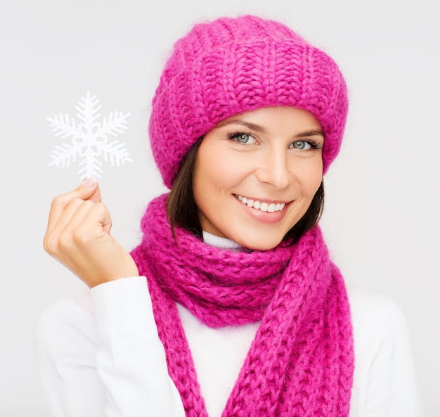 winter, people, happiness concept - woman in hat and muffler with big snowflake