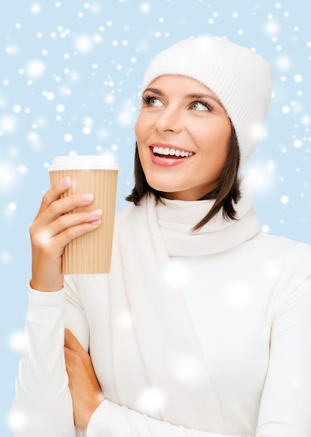 winter, people, happiness, drink and fast food concept - woman in hat with takeaway tea or coffee cup