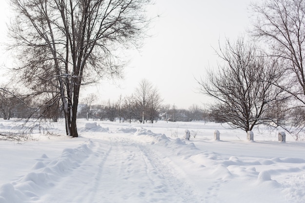 冬は道路の清掃が不十分です。雪が散らばって田舎の道。吹きだまりのある冬景色