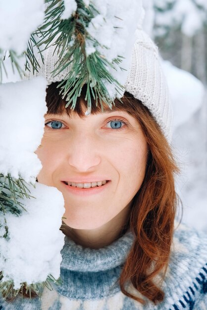 눈 덮인 나무 근처에서 아름 다운 여자의 겨울 초상화