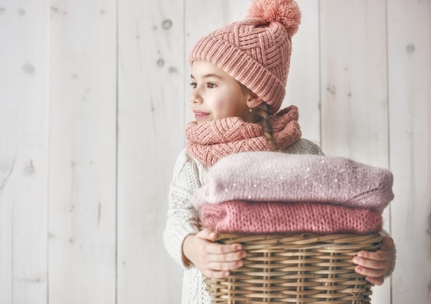 Winter portrait of happy little girl wearing knitted hat scarf and sweater