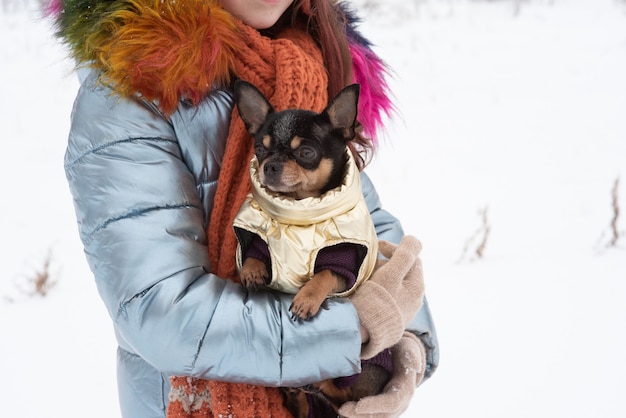 彼女の暖かい服を着た若い女の子の冬の肖像画。雪の降る天気で帽子をかぶった10代の少女。雪