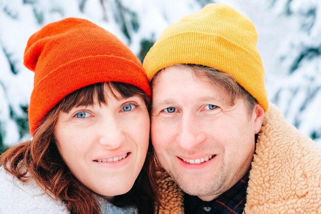 Winter portraits of a woman and a man in colored warm hats