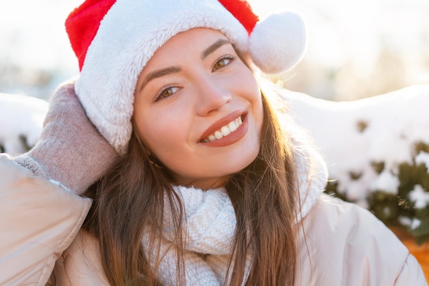 Winter portret jonge volwassen mooie vrouw in kerstmuts kerststemming sneeuwt Winter beauty fashion concept