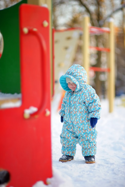 Winter portret van mooie peuter jongen op speelplaats
