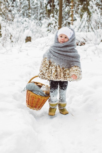 Winter portret van schattig glimlachend kind meisje op de wandeling in het zonnige besneeuwde bos