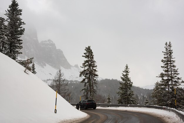 写真 イタリアのドロミット山脈の森の中の冬の道路